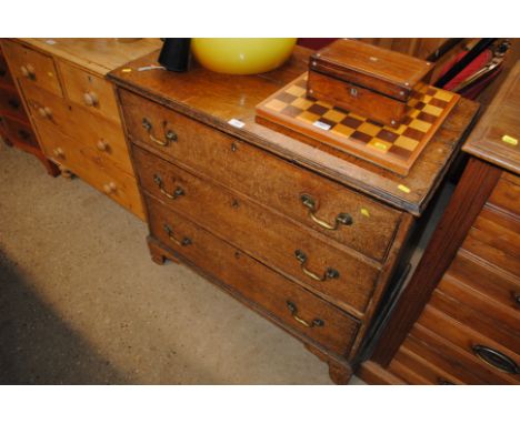 An oak chest fitted three long drawers raised on bracket supports 