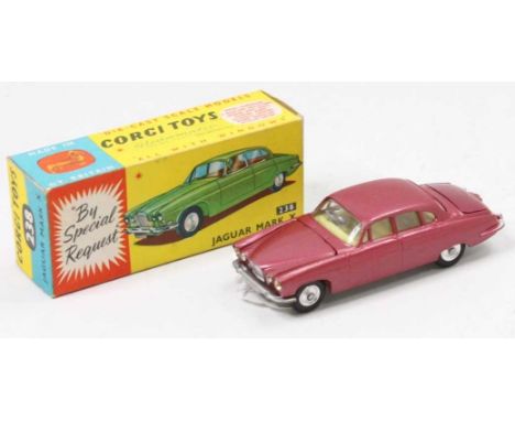 A Corgi Toys No. 238 Jaguar Mk 10 comprising metallic cerise body with lemon interior, spun hubs with two pieces of luggage i