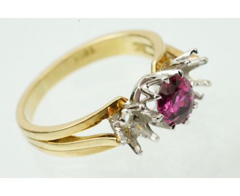 18ct gold and ruby ring set with a round mixed cut ruby between two vacant prong settings. Shank marked 18ct. Ruby measures a