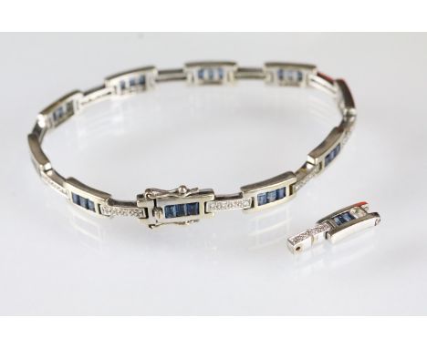18ct white gold, sapphire and diamond line bracelet. The bracelet having rectangular panels each set with blue step cut sapph
