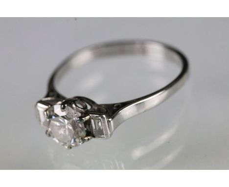 Platinum and diamond three stone ring being set with a round brilliant cut diamond to centre flanked by two step cut diamonds