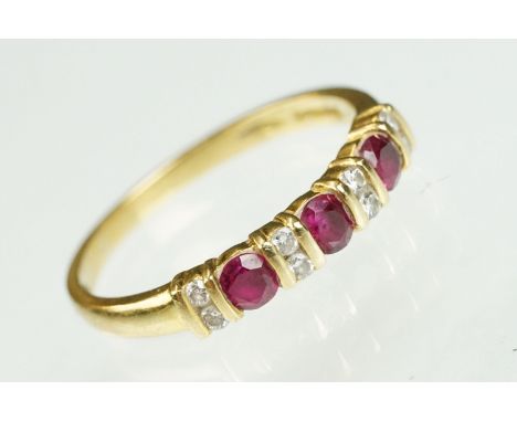 18ct gold ruby and diamond line ring. The ring being set with three round brilliant cut rubies, with diamond accent stones. H