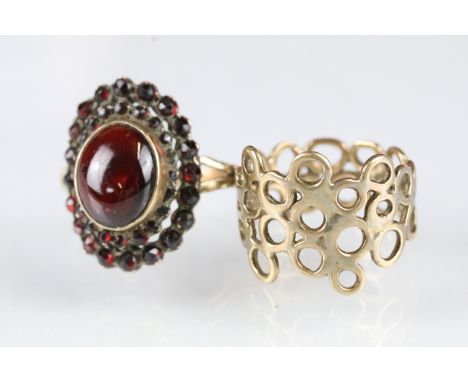 Yellow metal ring having a pierced design (size P.5, unmarked, tests indicate 9ct gold) together with a gold plated red stone