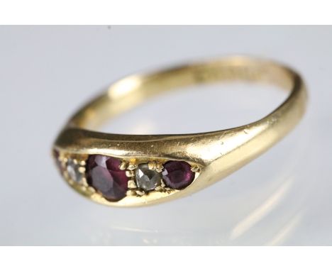 18ct gold ruby and diamond boat head ring being set with three round cut rubies, and two old cut diamonds. Hallmarked Birming