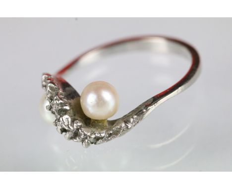 9ct white gold and pearl cross over ring. The ring set with two cultured pearl with pink overtones mounted to a textured cros