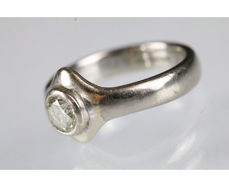 18ct white gold and diamond solitaire ring. The ring being bezel set with a round brilliant cut diamond to centre. Diamond es
