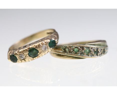 Two 9ct gold and green stone rings to include a cross over ring (size M.5), and a five stone ring set with diamonds and round
