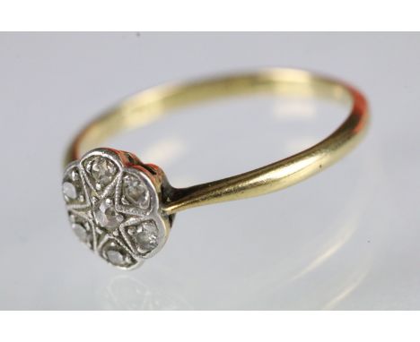 18ct and diamond daisy ring set with seven round cut diamonds. Marked 18ct. Size N. 