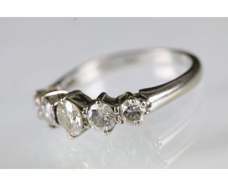 Five stone diamond ring being set with five round graduating diamonds in prong settings on a white gold shank. Hallmarks part