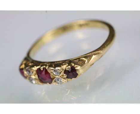 18ct gold ruby and diamond ring. The ring being set with an oval cut ruby to centre flanked by two round cut rubies and four 