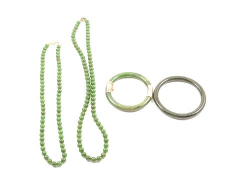 Two jade necklaces, one with sixty-three 8mm dark green beads, 55cm long; the other with seventy-seven 8.5mm similar beads 65