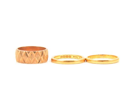 Three gold wedding rings, 9 carat yellow gold 7mm wide diamond cut D shape band ring size J, London 1970, 4g; 22 carat yellow