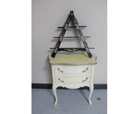 A white and gilt bedside chest and a triangular painted wall shelf 