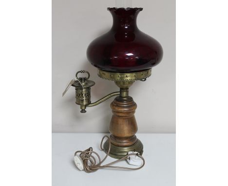 A continental wood and brass oil lamp with chimney and red glass shade (wired) 