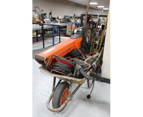 A wheelbarrow containing an Ozito pressure washer, flymo garden vacuum, extension reel and a large quantity of garden tools 