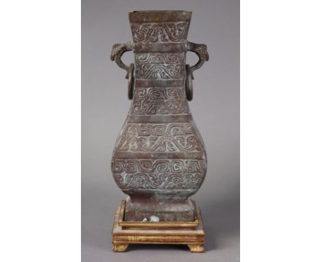 An archaic style Chinese bronze vase/table lamp base with zoomorphic ring handles, 34cm high, on wooden base. (lacking fittin