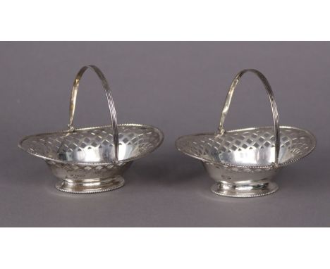 A pair of George V silver oval sweetmeat baskets, each with pierced sides, beaded rim, &amp; swing handle, 12cm wide; Birming