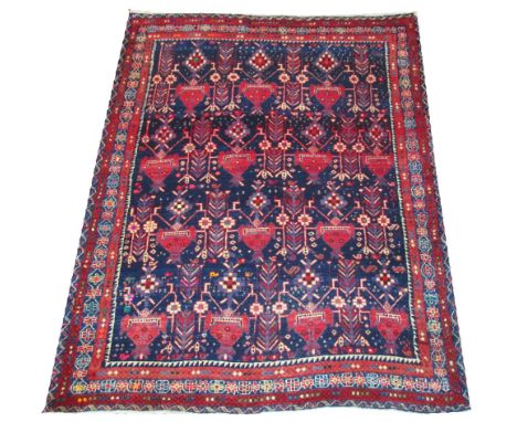 VINTAGE SIRJAN CARPET, 185cm x 148cm, repeat stylised vase, leaf and flower design on a midnight blue field inside multiple g