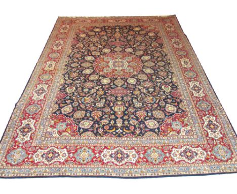 FINE VINTAGE KASHAN CARPET, 405cm x 302cm, organic ruby medallions on a midnight blue field of scrolling vines and palmettes 