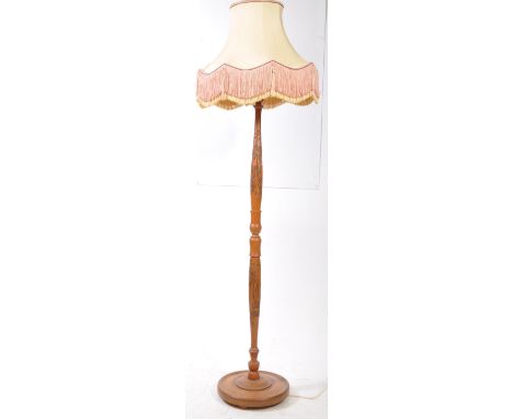 A vintage 20th century Chinese manner carved floor standing standard lamp. The lamp having a rounded base, with turned centra
