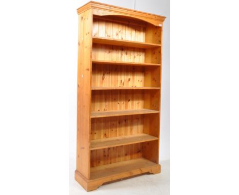 A contemporary country pine farmhouse open window bookcase. The bookcase raised on bracket feet, with a series of open window