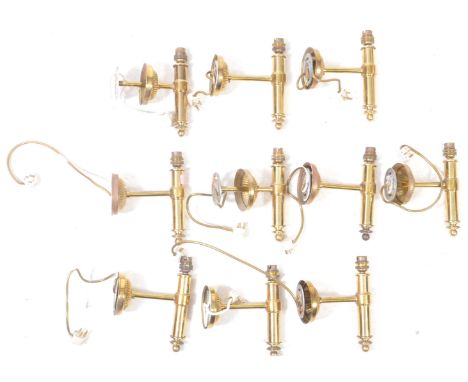 A collection of nine contemporary brass wall sconces. Each sconce having rounded mount with gadrooned detail, and reverse fin