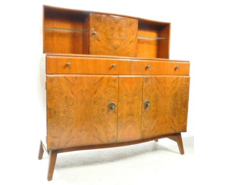 A vintage mid 20th century 1950s post-war Art Deco walnut cocktail displat cabinet sideboard. The credenza having a serpentin