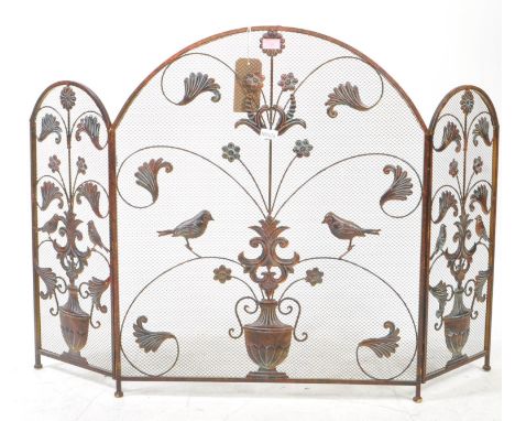 A vintage 20th century metal decorated firescreen. Triptych stand with bi folding mesh panels. With foliate and bird figure d