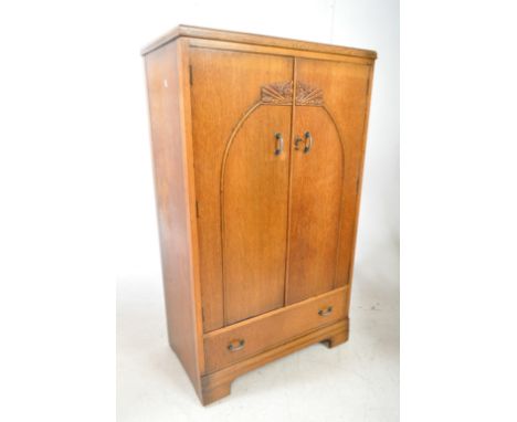 An early 20th century 1940s Art Deco manner oak bachelors wardrobe. The wardrobe raised on block feet, having a drawer to low