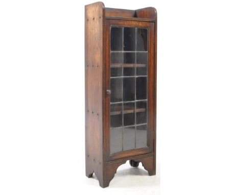 A 1920s small solid oak and leaded glazed bookcase cabinet.. Galllery top with lead front glazed door with wooden shelves wit