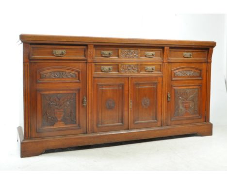 A late 19th century Arts &amp; Crafts oak sideboard credenza, The sideboard featuring urn design to doors having a bank of sh