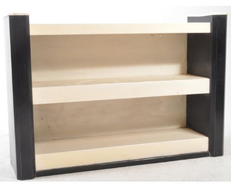 A mid 20th century circa 1940s Art Deco metal painted floor shelf unit having three shelves flanked by cantered upright suppo
