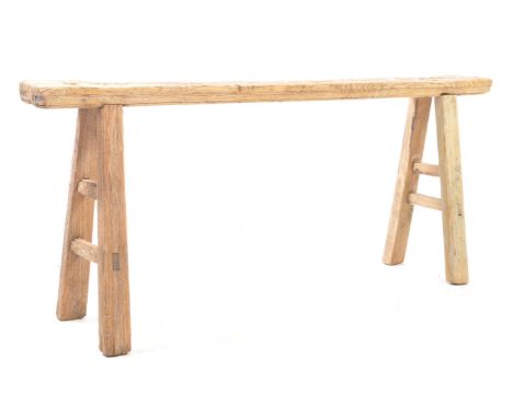 A vintage 20th century rustic reclaimed elm pig bench. Having peg joint angled feet united by stretcher with plank top. Measu