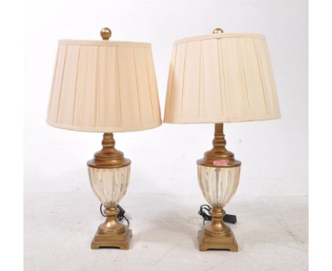 A pair of contemporary brass effect and glass table lamps. Each lamp raised on a pedestal base, with fluted glass body and br