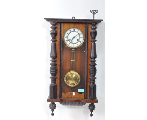 An early 20th century mahogany Vienna regulator wall clock. With pediment top white enamelled face on an ebonised Roman numer