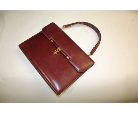 HERMES LEATHER HANDBAG a burgundy leather handbag with brass clasp and leather and brass handle. With various internal compar