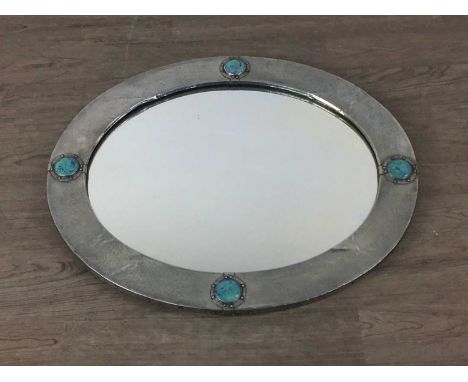 LIBERTY & CO, ARTS & CRAFTS PEWTER WALL MIRROR, CIRCA 1900  of oval form, hammered finish, set with four Ruskin high-fired po