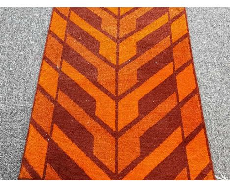 AXMINSTER CARPET RUNNER OF ART DECO DESIGN, POST-WAR in burnt orange and burgundy with chevron design565cm x 70cmWould certai