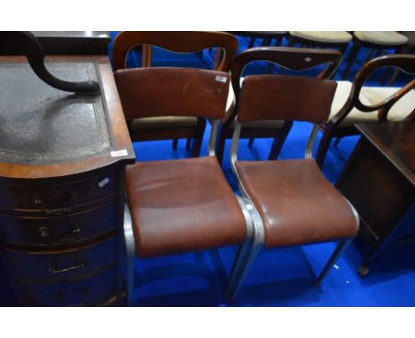 A pair of vintage chairs having metal frames and textured vinyl seats