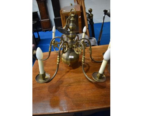 A vintage brass electrolier ceiling light fitting , having 6 branches and mythical figurehead decoration with candle type fit