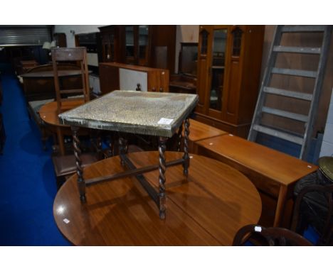 A vintage brass top table having oak twist folding frame , approx 54 x 54cm