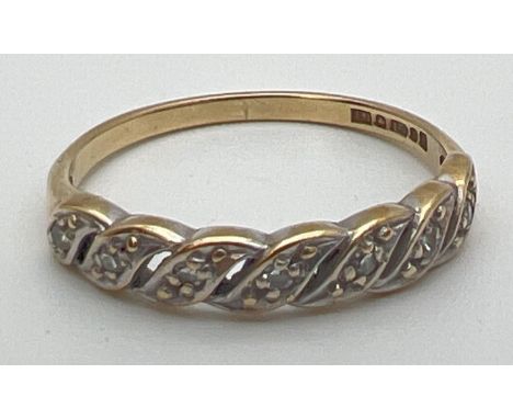 A vintage 9ct gold and diamond eternity style ring with a twisted design setting. Open pierced work mount set with 7 small di