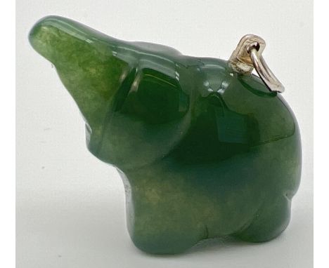 A carved jade pendant in the form of an elephant, with white metal hanging bale. Approx. 2.5cm x 3cm and weighs approx. 11.8g