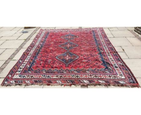 A Persian carpet, with three medallions, on a red ground, 294 x 213 cm