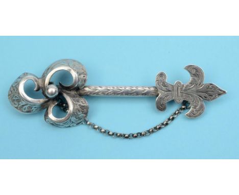 A 19th century silver cloak brooch, in the from of a stylised Celtic arrow, with sprung clasp and chain, with engraved decora