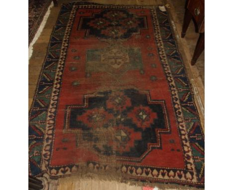 A Kazak rug, decorated geometric motifs, on a red ground, dated 1911, within a multi border, 225 x 145 cm