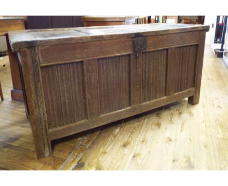 An 18th century oak coffer, with a linen fold panel front, on stile legs, 145 cm wide