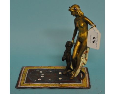 A painted metal group, of a female with a pet lion, on a Persian carpet, 16.5 cm high