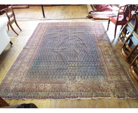A Persian carpet, with stylised floral motifs, on a blue ground, 290 x 245 cm