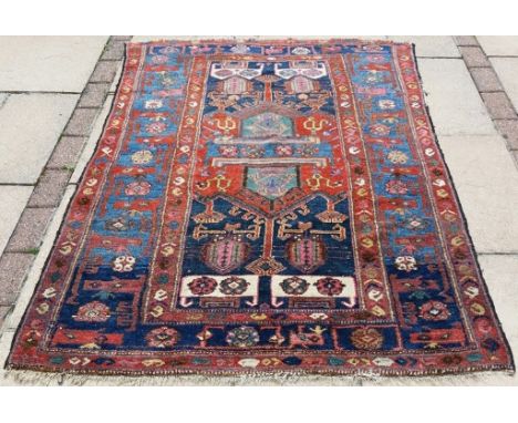 A Persian rug, decorated stylised motifs, on a red ground, 180 x 121 cm